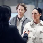 Car buyer at a kitchen table reviewing credit reports and loan options before applying