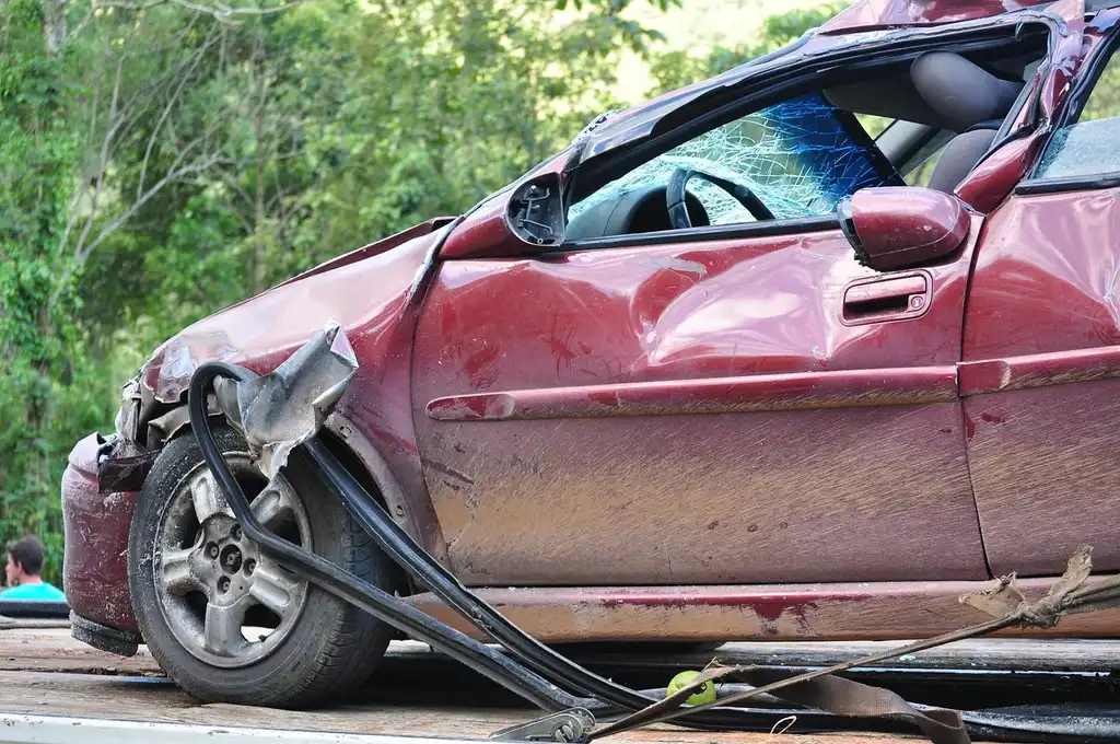 Used-car buyer comparing two sedans and checking insurance cost factors on a smartphone