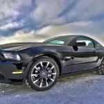 Private car sale closing with buyer, seller, cashier’s check, and title paperwork beside a sedan