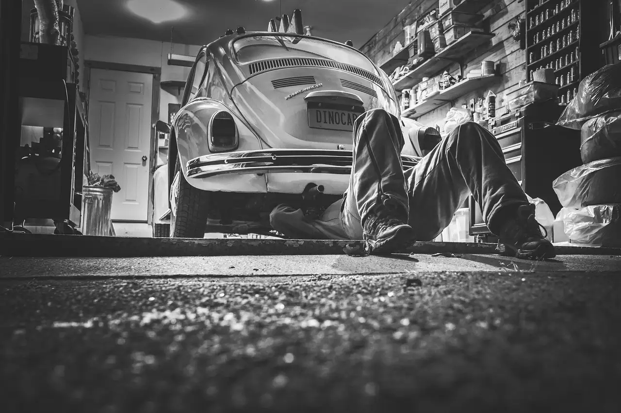 A shopper and mechanic discussing a used sedan in a dealership lot before purchase
